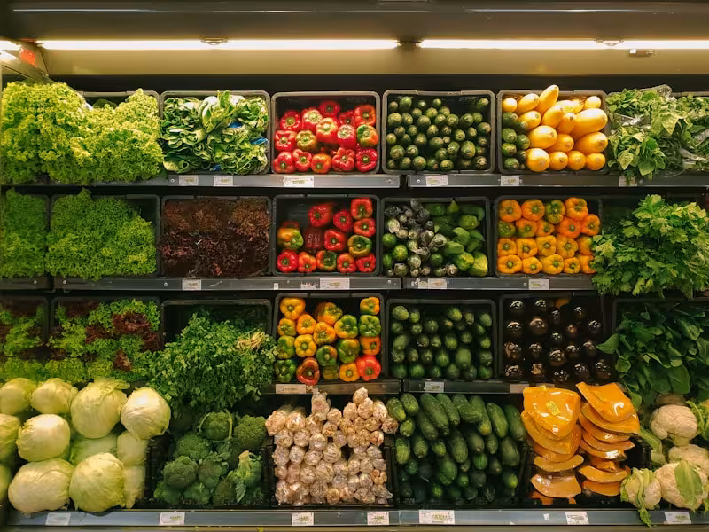 A diverse spring farmers market stall with fresh seasonal vegetables